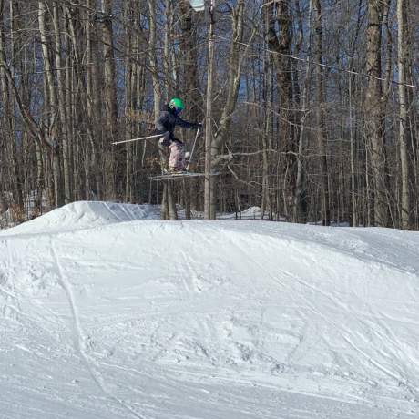 Young skier jumping hill in terrain park