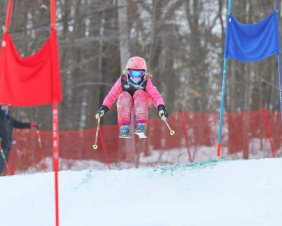 Young skier midair over a jump